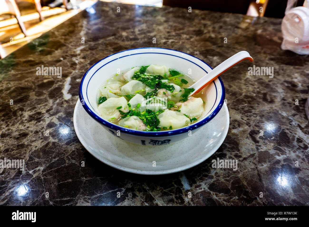 Köstliche chinesische Hundun Suppe in eine Schüssel mit Gemüse und Löffel Stockfoto