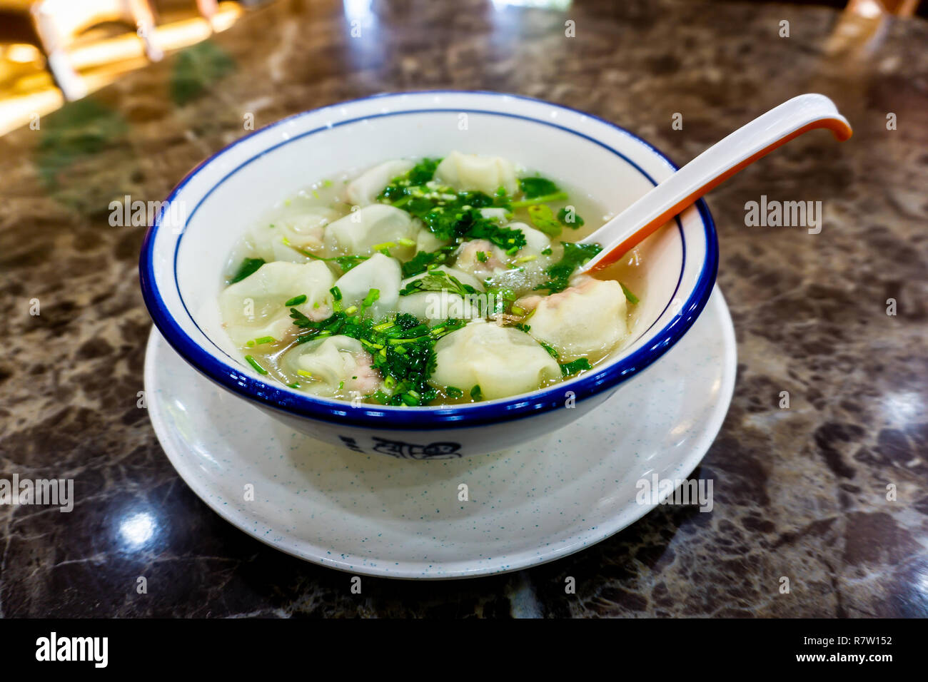 Köstliche chinesische Hundun Suppe in eine Schüssel mit Gemüse und Löffel Stockfoto