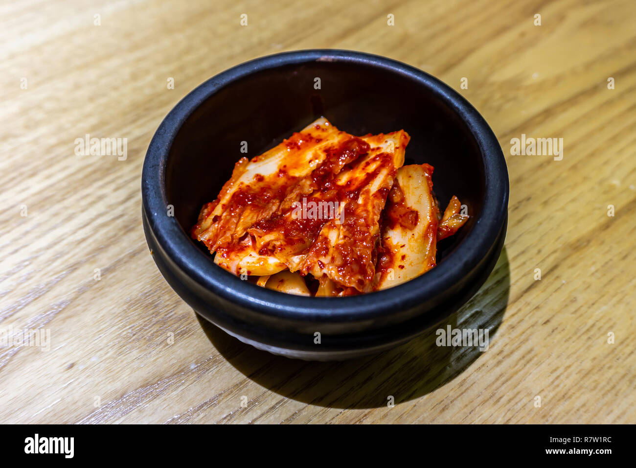 Koreanisches Kimchi in einem kleinen schwarzen Schale mit roten Chili Sauce Stockfoto
