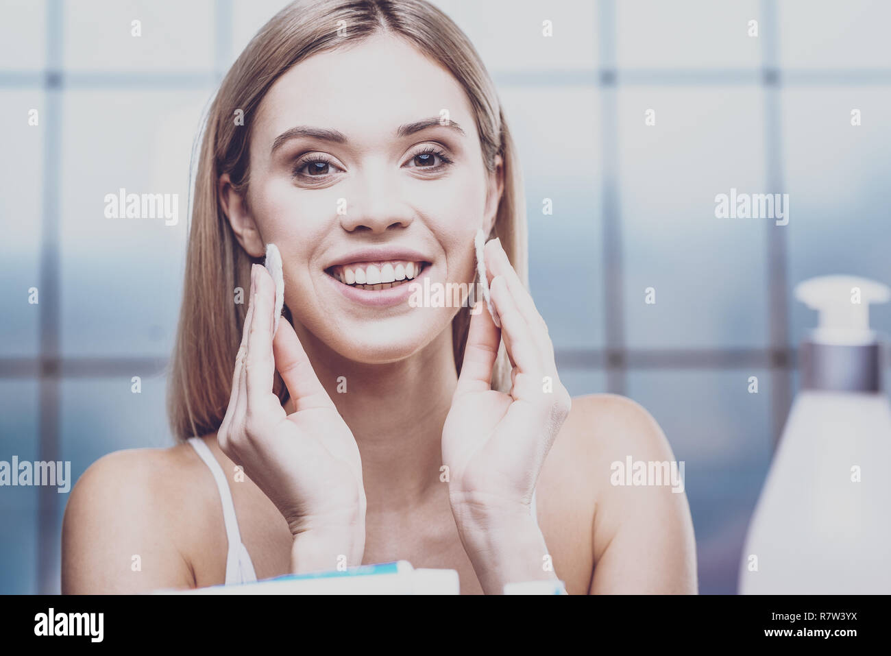 Positive junge Frau ihr Gesicht Reinigung Stockfoto