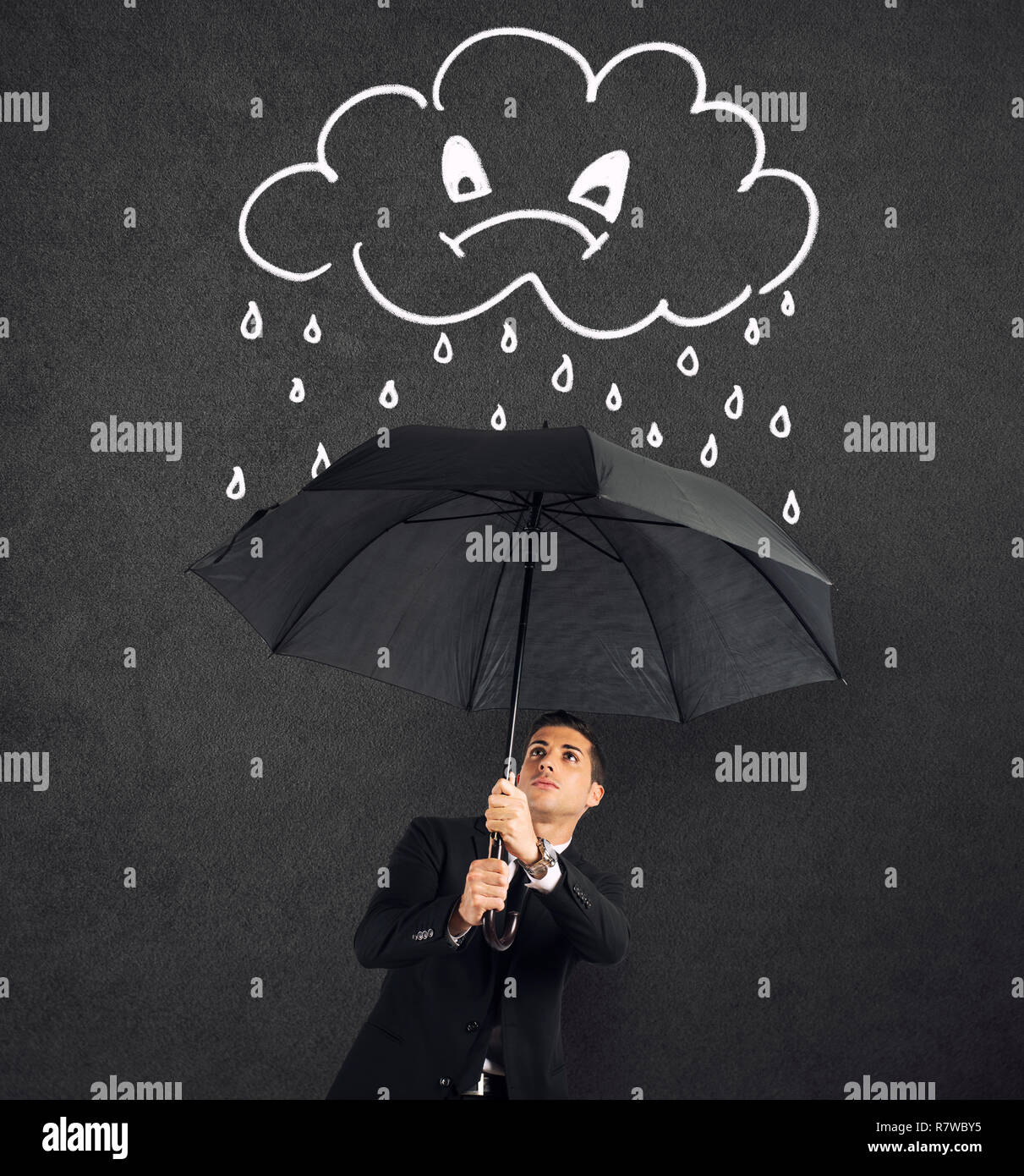 Geschäftsmann mit Regenschirm und eine wütende Wolke mit Regen. Konzept der Krise und finanzielle Schwierigkeiten Stockfoto