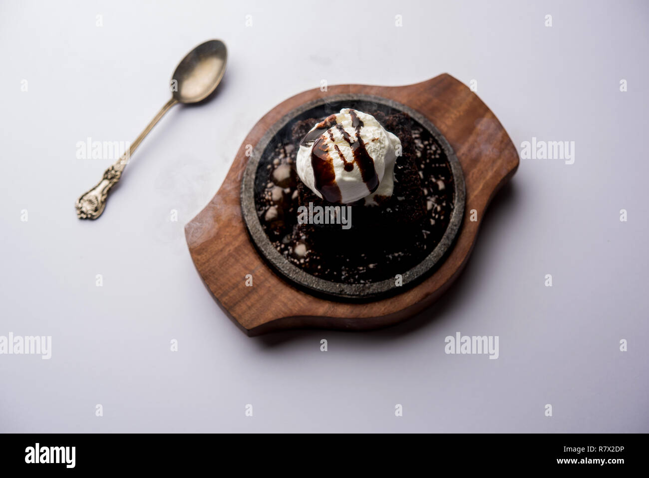 Sizzling Chocolate Brownie ist eine Süßspeise, die mit Kugel Eis-Creme auf der Oberseite mit einem großzügigen Gießen der geschmolzene Schokolade serviert. Server heiß. wählen Stockfoto