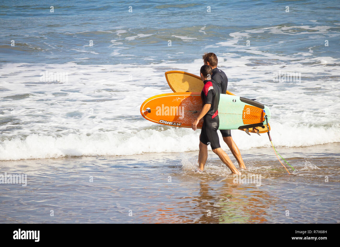 Surfer gehen am Strand mit Surfboards. Stockfoto
