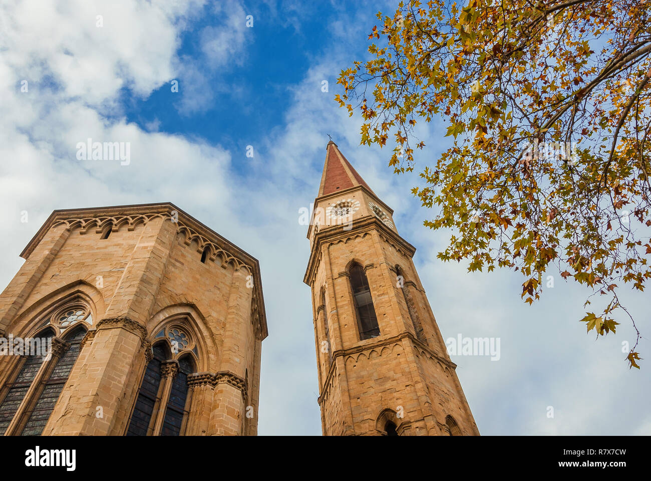 Herbst und Winter in Arezzo. Blick auf die gotische Kathedrale Apsis und berühmten Glockenturm mit gelben Blättern und bewölkter Himmel Stockfoto