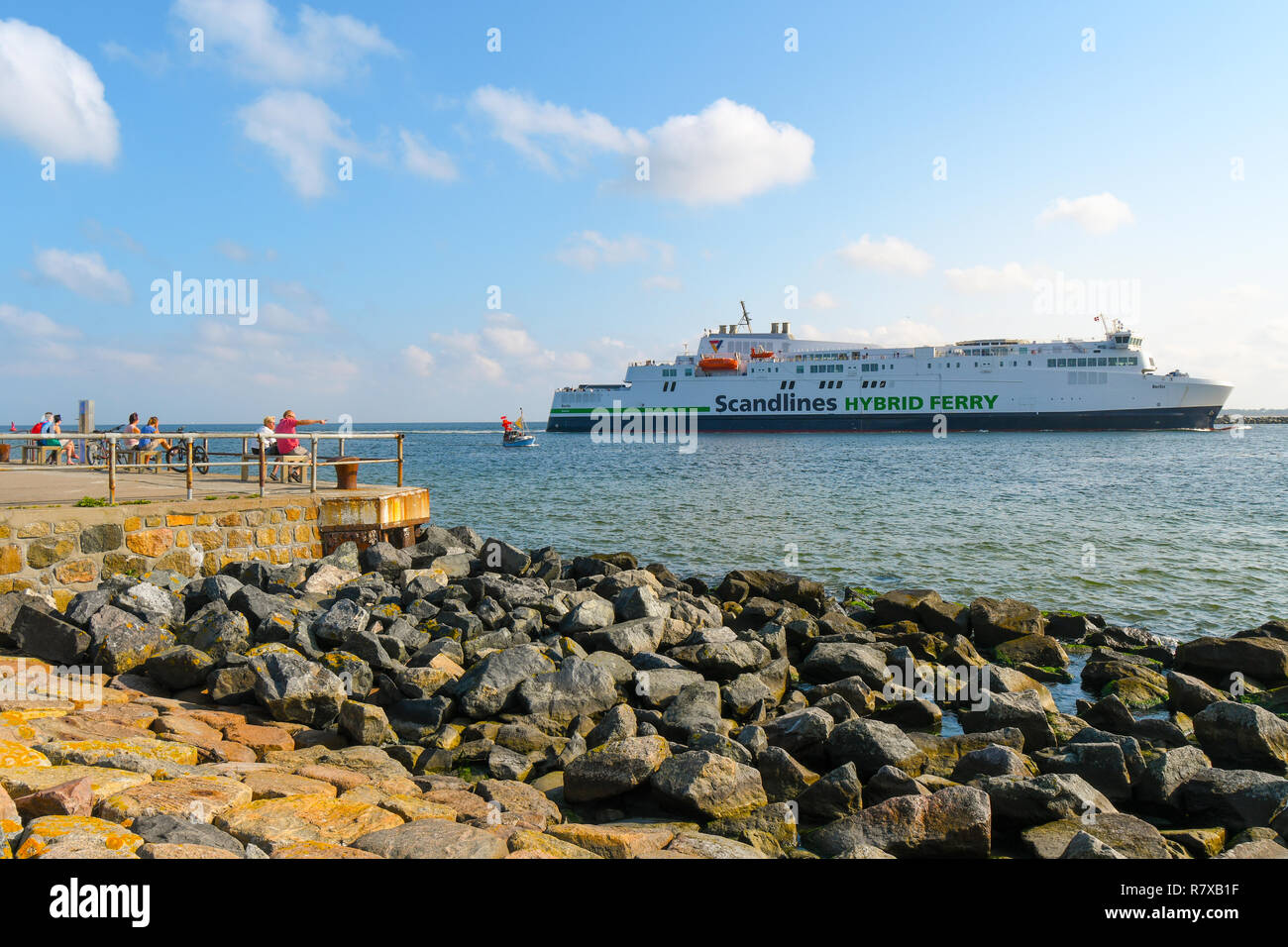 Touristen auf der Promenade an der Küste der Ostsee entspannen Sie sich, wie Sie beobachten, Fähren Kreuzfahrt aus dem Hafen von Warnemünde Rostock, Deutschland Stockfoto