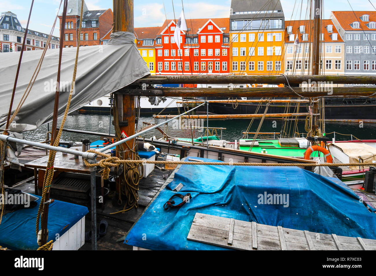 Der Hund entspannt sich auf Deck eines Segelboot in der Nyhavn Kanal durch die bunten Gebäude und Geschäfte im historischen Zentrum von Kopenhagen, Dänemark umgeben Stockfoto
