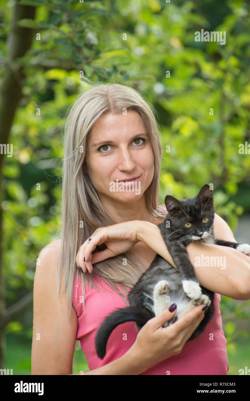 Mädchen, dass eine schwarze Katze mit einem unscharfen Hintergrund Stockfoto