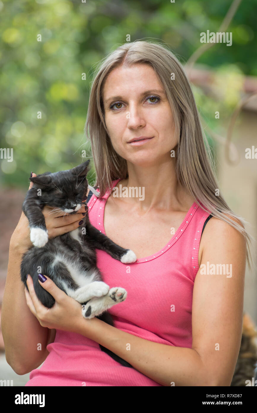 Mädchen, dass eine schwarze Katze mit einem unscharfen Hintergrund Stockfoto