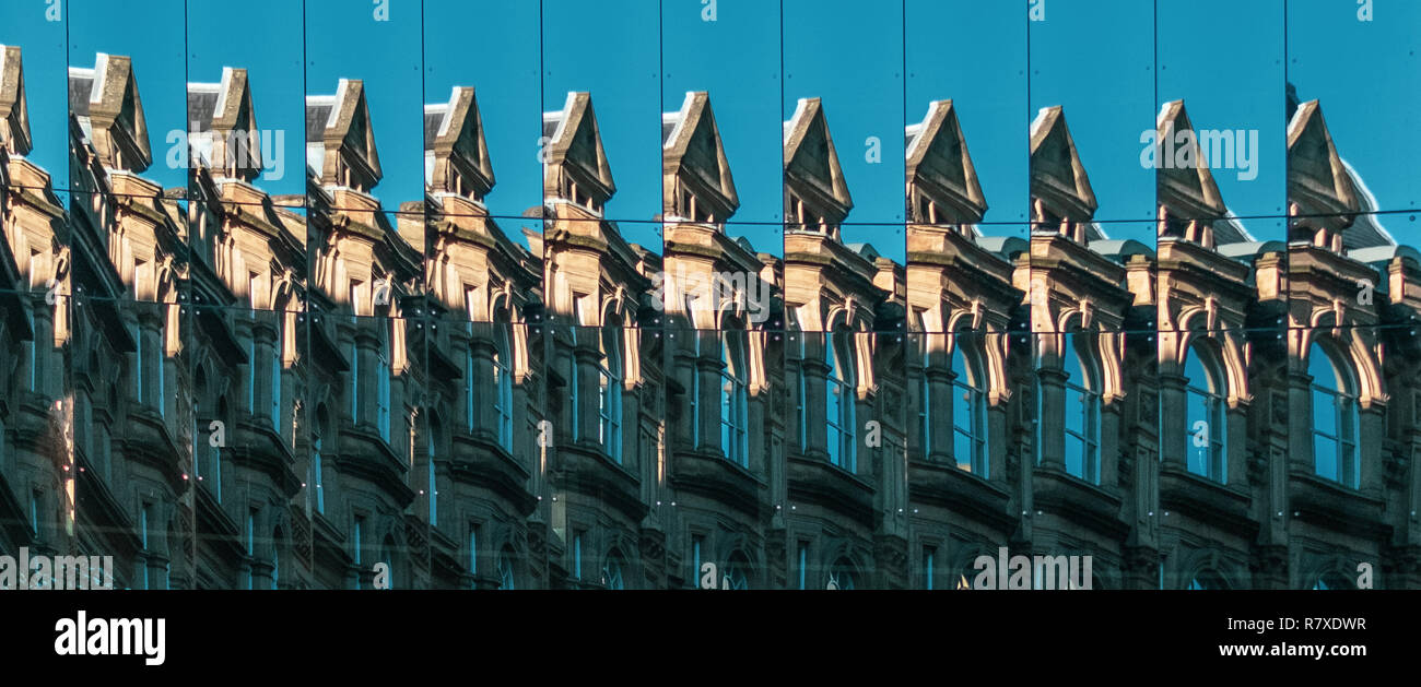 Gebäude reflektiert in mehreren verspiegelten Fenstern. Spiegelbild. Gebäude in der Sonne reflektiert. Fenster und Spiegel. Stockfoto