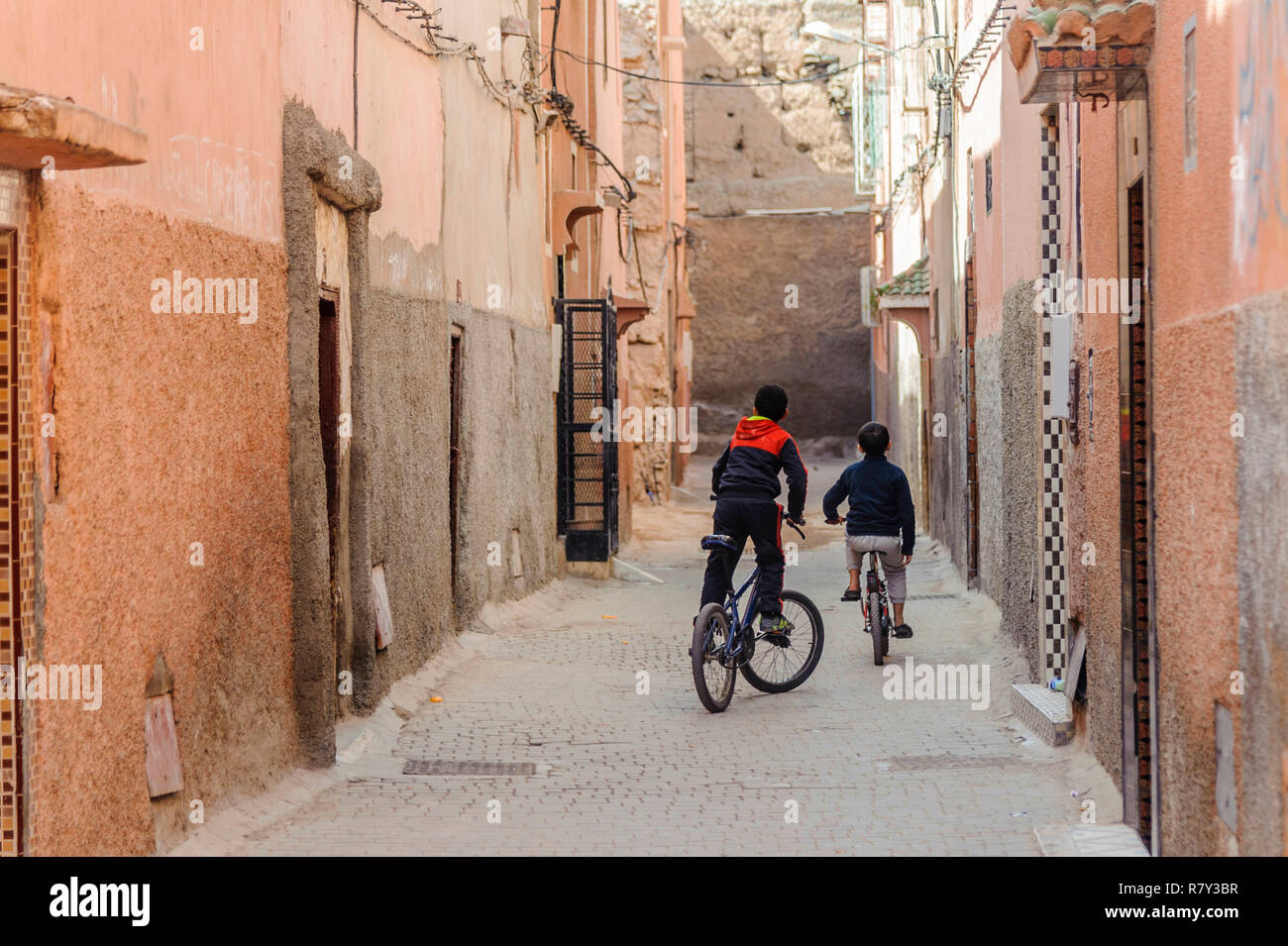 05-03-15, Marrakesch, Marokko. Zwei Jungen spielen auf ihre Fahrräder in der alten, alten Medina Teil der Stadt. Foto: © Simon Grosset Stockfoto