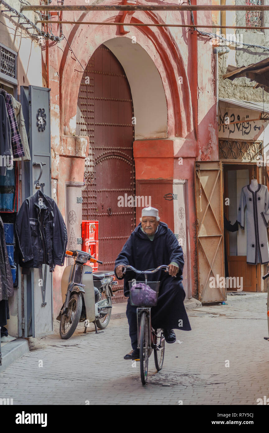 05-03-15, Marrakesch, Marokko. Street Scene im Souk, in der Medina, in der alten, alten Teil der Stadt. Ein Mann fährt mit dem Fahrrad nach unten eine Straße, Alle Stockfoto