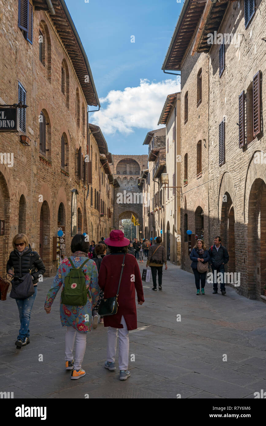 Vertikale Ansicht von Touristen im Tor von San Gimignano, Italien. Stockfoto