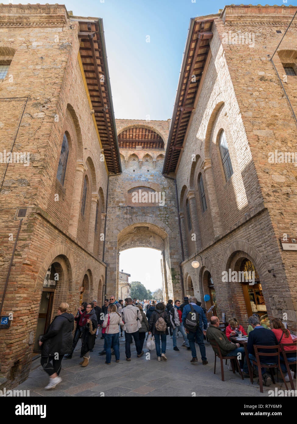 Vertikale Ansicht von Touristen im Tor von San Gimignano, Italien. Stockfoto