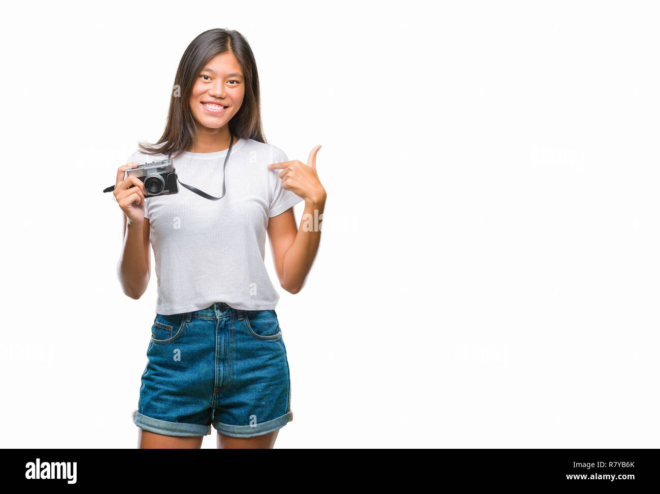 Junge asiatische Frau mit vintagera Foto Kamera über isolierte Hintergrund mit Überraschung Gesicht zeigenden Finger zu sich selbst Stockfoto