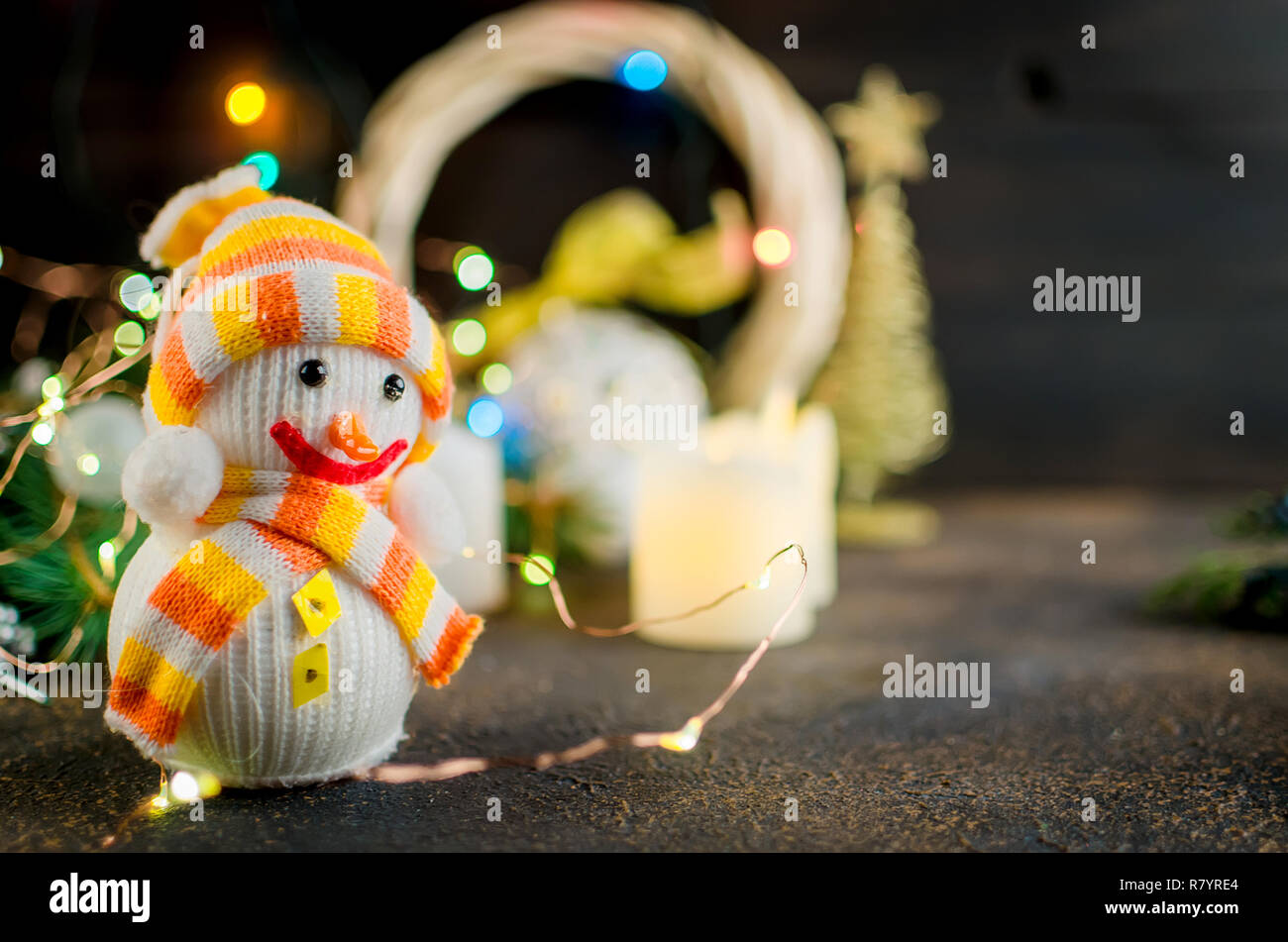 Weihnachten Komposition mit einem Schneemann, craft Geschenke mit einem roten Seil, Tannenzweigen und Lichter auf dunklem Hintergrund gebunden. Karte Holiday Konzept. Kopieren Sie Raum, Stockfoto