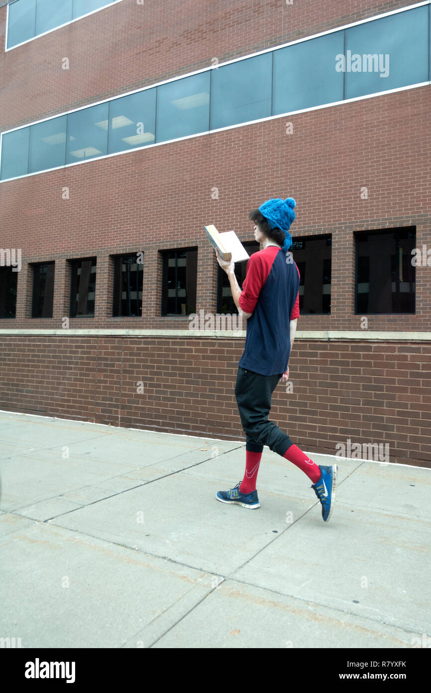 Lean Schüler lesen ein Buch, während bei einem Spaziergang das Tragen sehr stilvolle Kleidung. St. Paul Minnesota MN USA Stockfoto