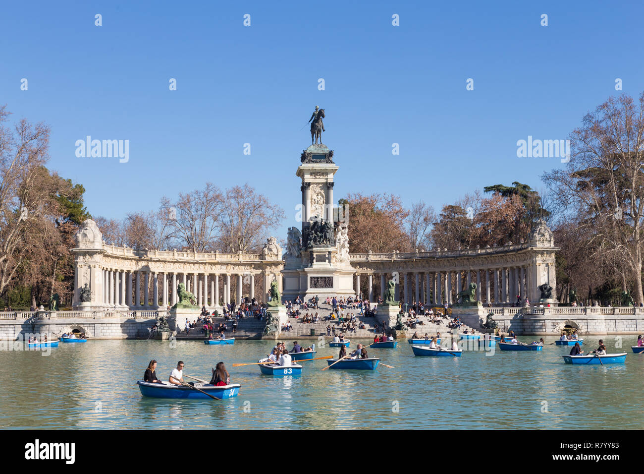 Touristen rudern traditionell blau Boote auf dem See in Retiro Park an einem schönen sonnigen Tag in Madrid, Spanien. Stockfoto