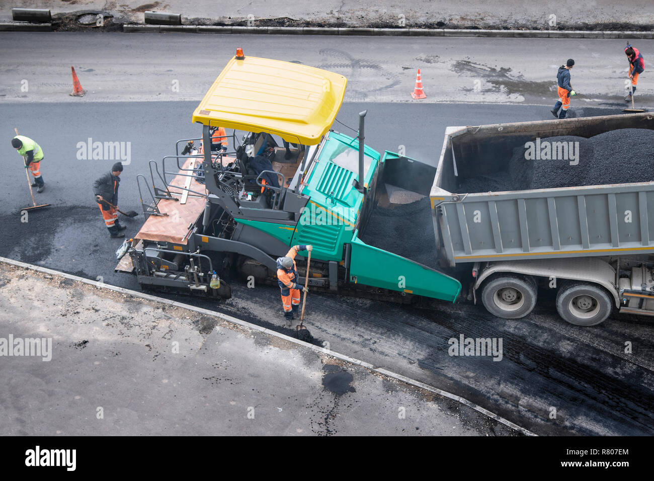 Asphalt fertiger Maschine oder fertiger Finisher und Straßenbau Arbeiter setzen eine Schicht von frischem Asphalt. Straße Erneuerung, Bau arbeiten. Hohe Stockfoto