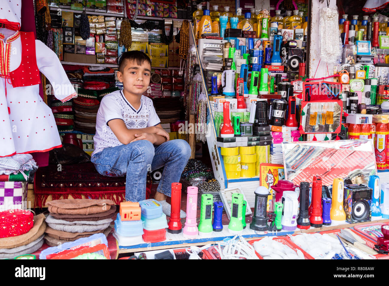 Khorog, Tadschikistan 25. August 2018: schöner Junge sitzt in seinem Stall, warten auf Käufer seine Waren, Khorog, Tadschikistan Stockfoto