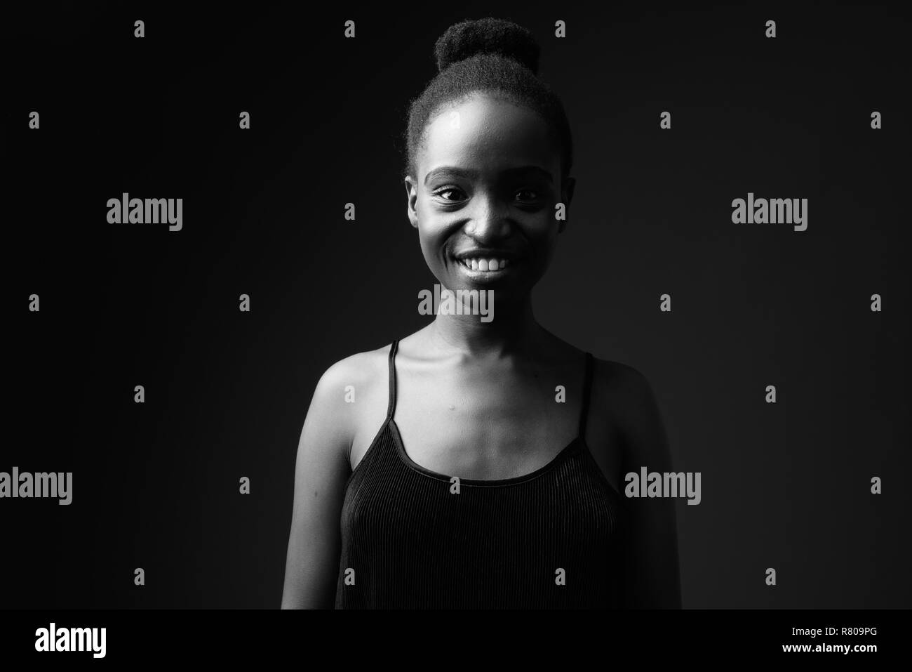 Schwarz-weiß-Porträt der jungen schönen afrikanischen lächelnde Frau Stockfoto