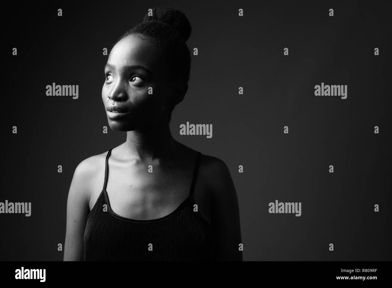 Schwarz-weiß-Porträt der jungen schönen afrikanischen Frau denken Stockfoto