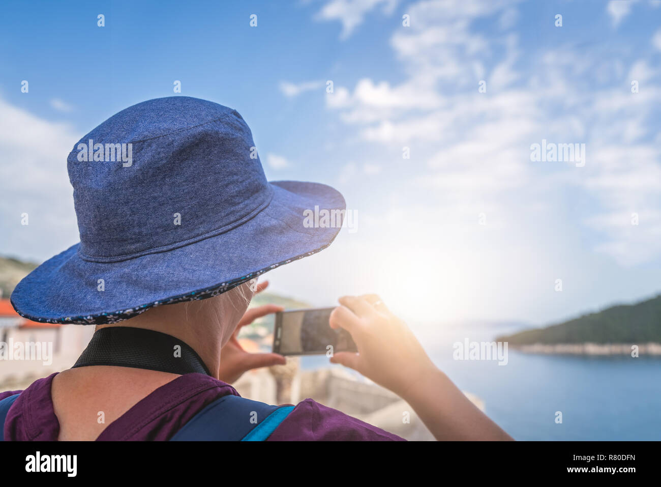 Kaukasische Frau mit einem blauen Hut, die Bilder von den historischen Mauern der Altstadt von Dubrovnik, Kroatien im Sommer Stockfoto