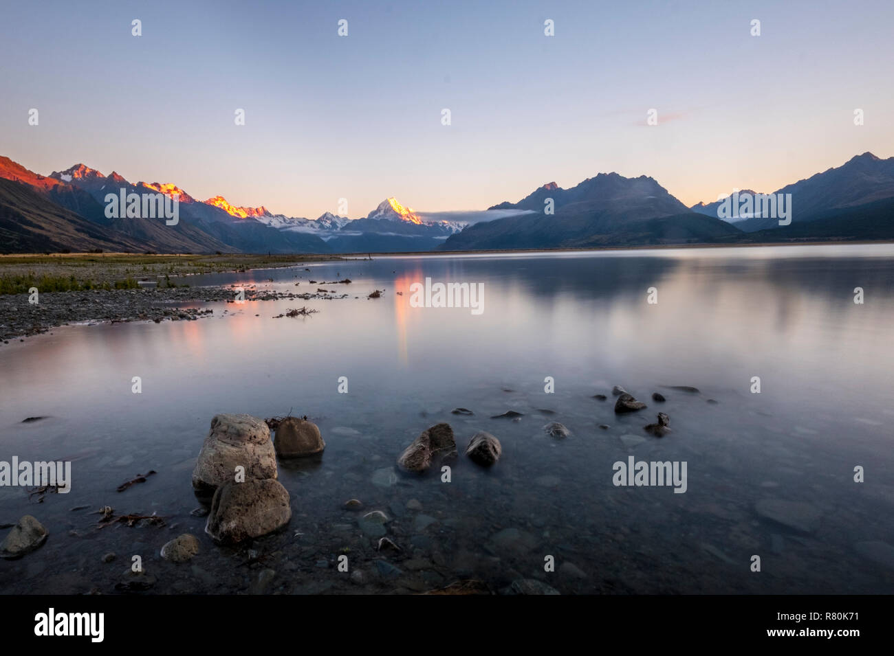 Blick zum Mount Cook von Pukaki See. Schöne Berge in den Sonnenaufgang. Ruhigen Wasser. Steine und Reflexionen. Stockfoto