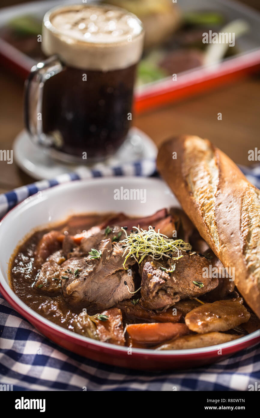 Gebratenes Wildschwein mit Karotten Pilze, Baguette und Bier vom Fass. Stockfoto