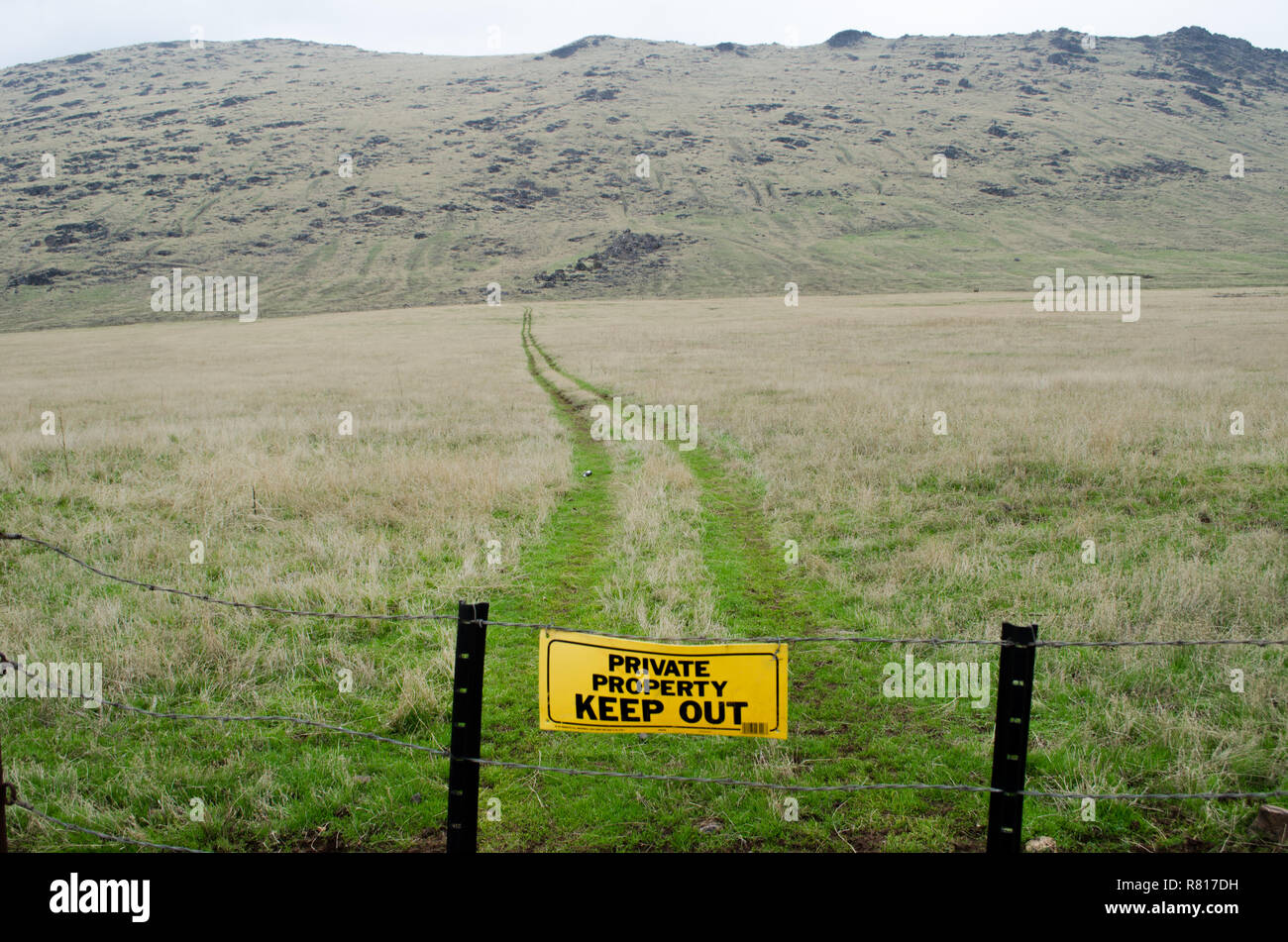 "Privateigentum heraus Halten' Zeichen auf Zaun mit offenen Weide und Trail hinter sich. Stockfoto