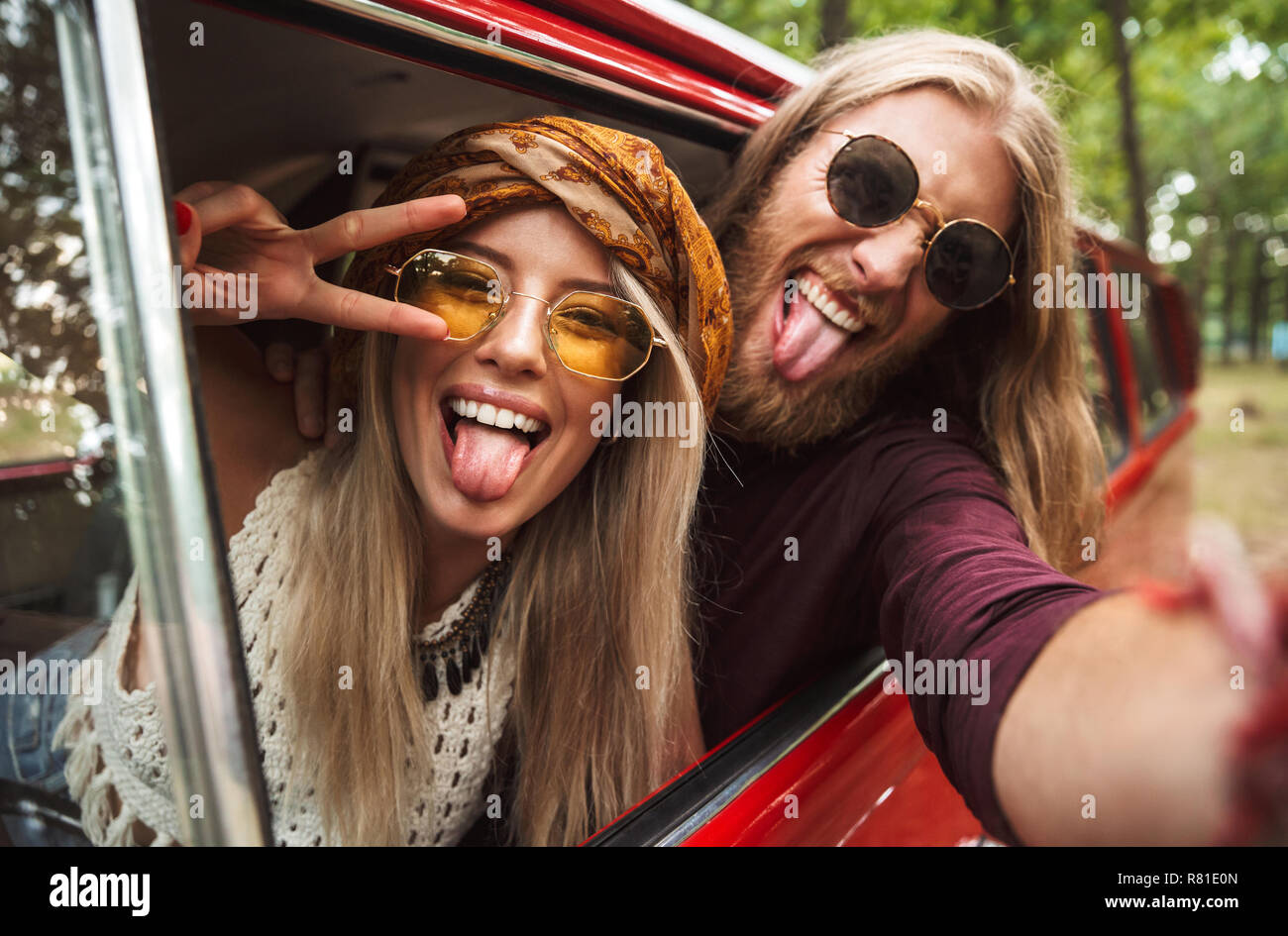 Foto des schönen hipster Paar lächelnd und mit Frieden Zeichen während der Fahrt retro minivan im Wald Stockfoto