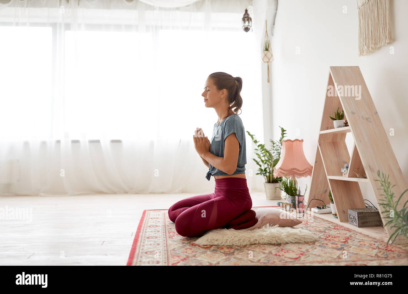 Frau Meditation im Lotussitz auf Yoga Studio Stockfoto