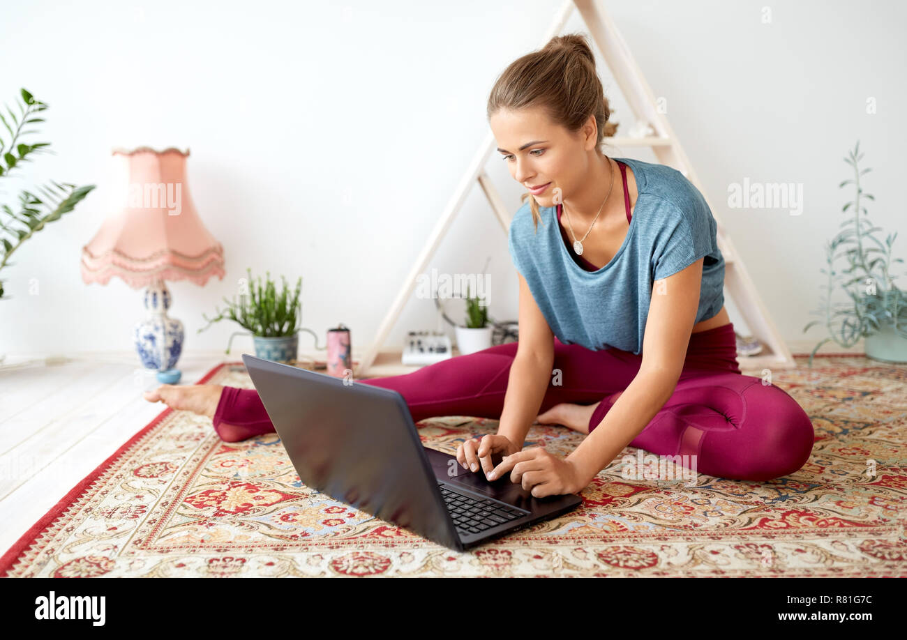 Frau mit Laptop bei Yoga Studio Stockfoto