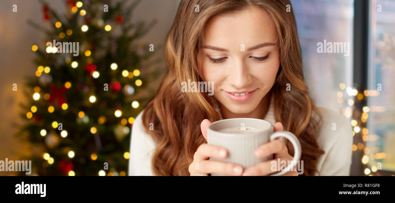 Glückliche Frau mit einer Tasse Tee oder Kaffee auf Weihnachten Stockfoto