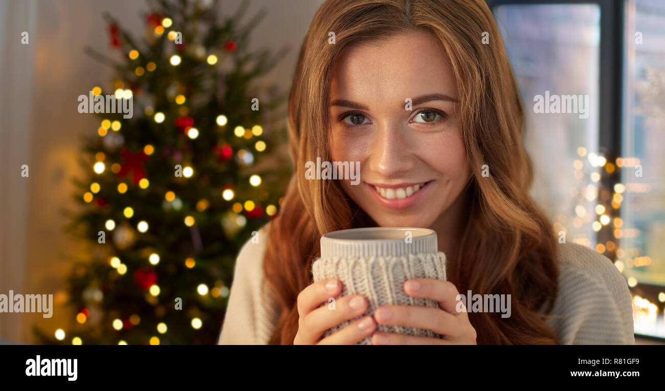 Glückliche Frau mit einer Tasse Tee oder Kaffee auf Weihnachten Stockfoto