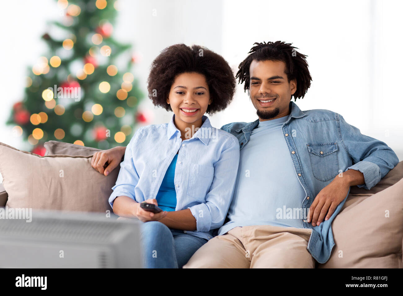 Glückliches Paar Fernsehen zu Hause an Weihnachten Stockfoto