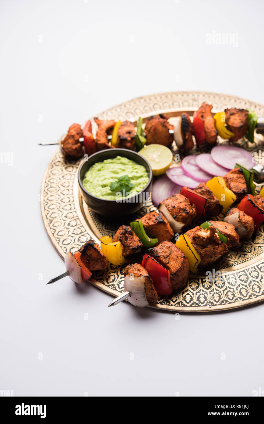 Chicken Tikka/skew Kebab. Traditionelle indische Gericht gekocht auf Holzkohle und Flamme, gewürzt & bunt garniert. Mit grüner Chutney und Salat serviert. Stockfoto