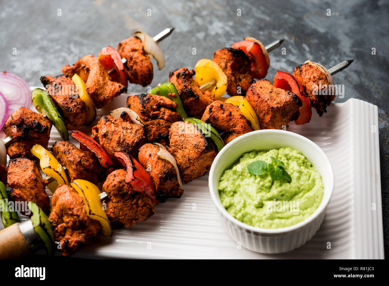 Chicken Tikka/skew Kebab. Traditionelle indische Gericht gekocht auf Holzkohle und Flamme, gewürzt & bunt garniert. Mit grüner Chutney und Salat serviert. Stockfoto