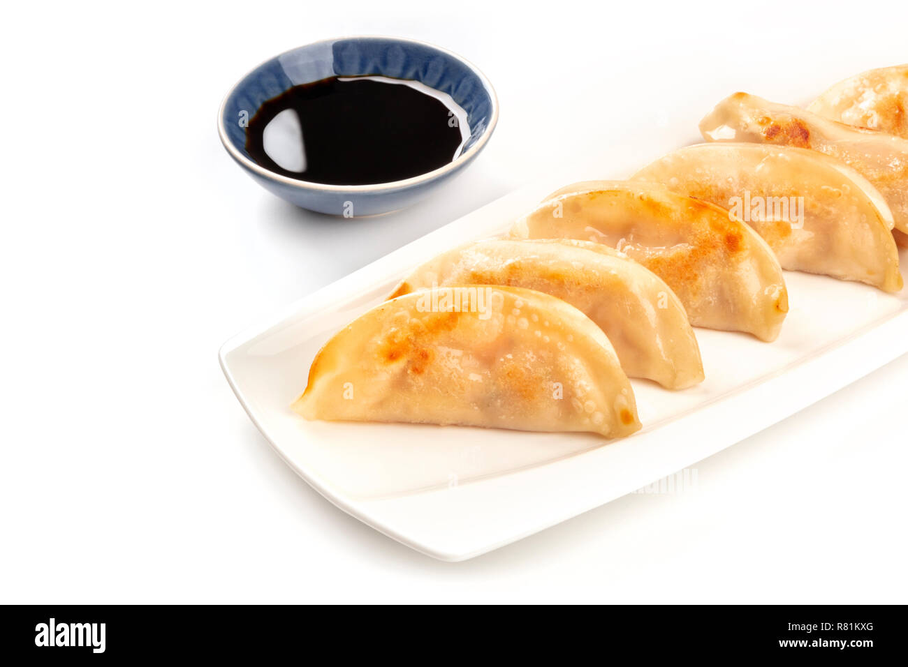 Gyozas, asiatische Knödel, auf einem weißen Hintergrund mit einer Schüssel mit Sojasauce und ein Platz für Text Stockfoto