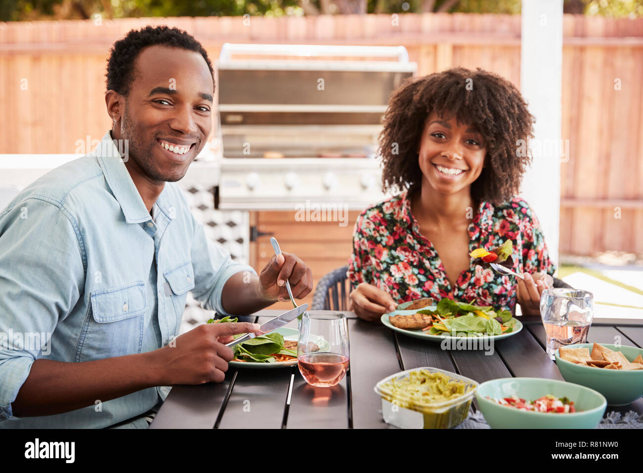 Junge schwarze Paar Essen im Garten Kamera suchen Stockfoto