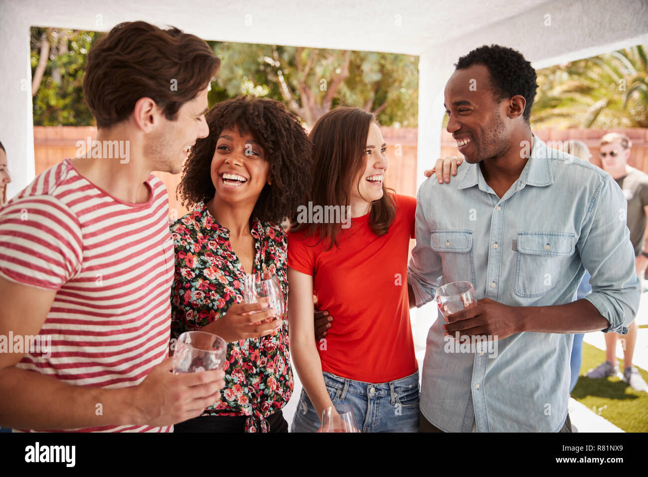 Junge Erwachsene Freunde sprechen in einem Hinterhof Partei Stockfoto
