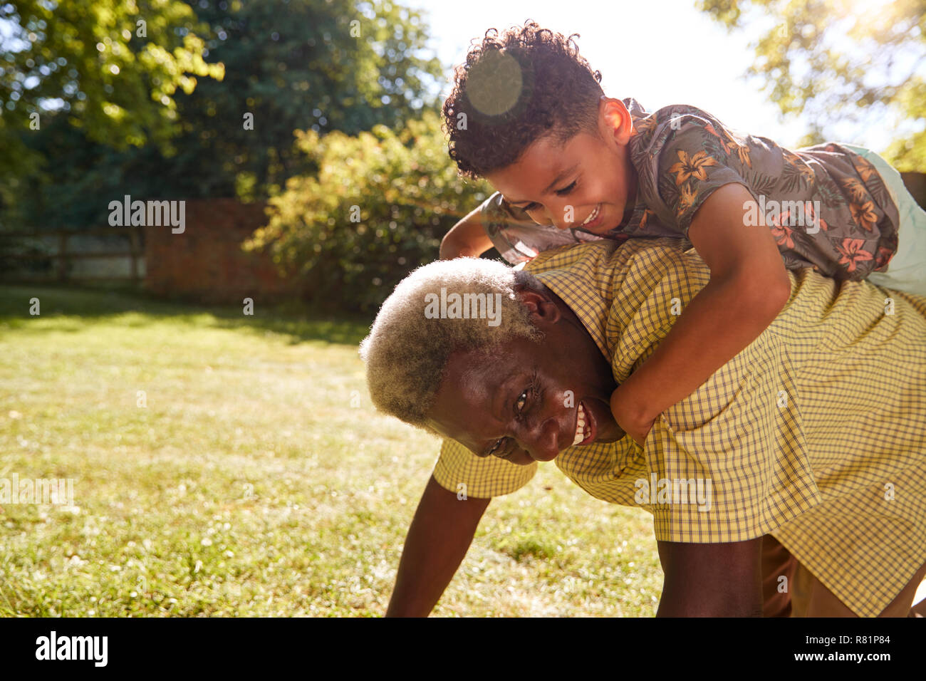 Älteren schwarzen Mann mit Enkel reiten auf dem Rücken Stockfoto