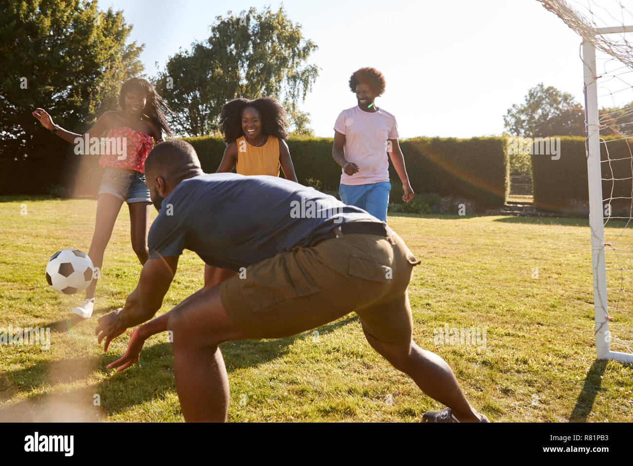 Die vier schwarzen Erwachsenen Freunde in ein lustiges Spiel Fußball Stockfoto