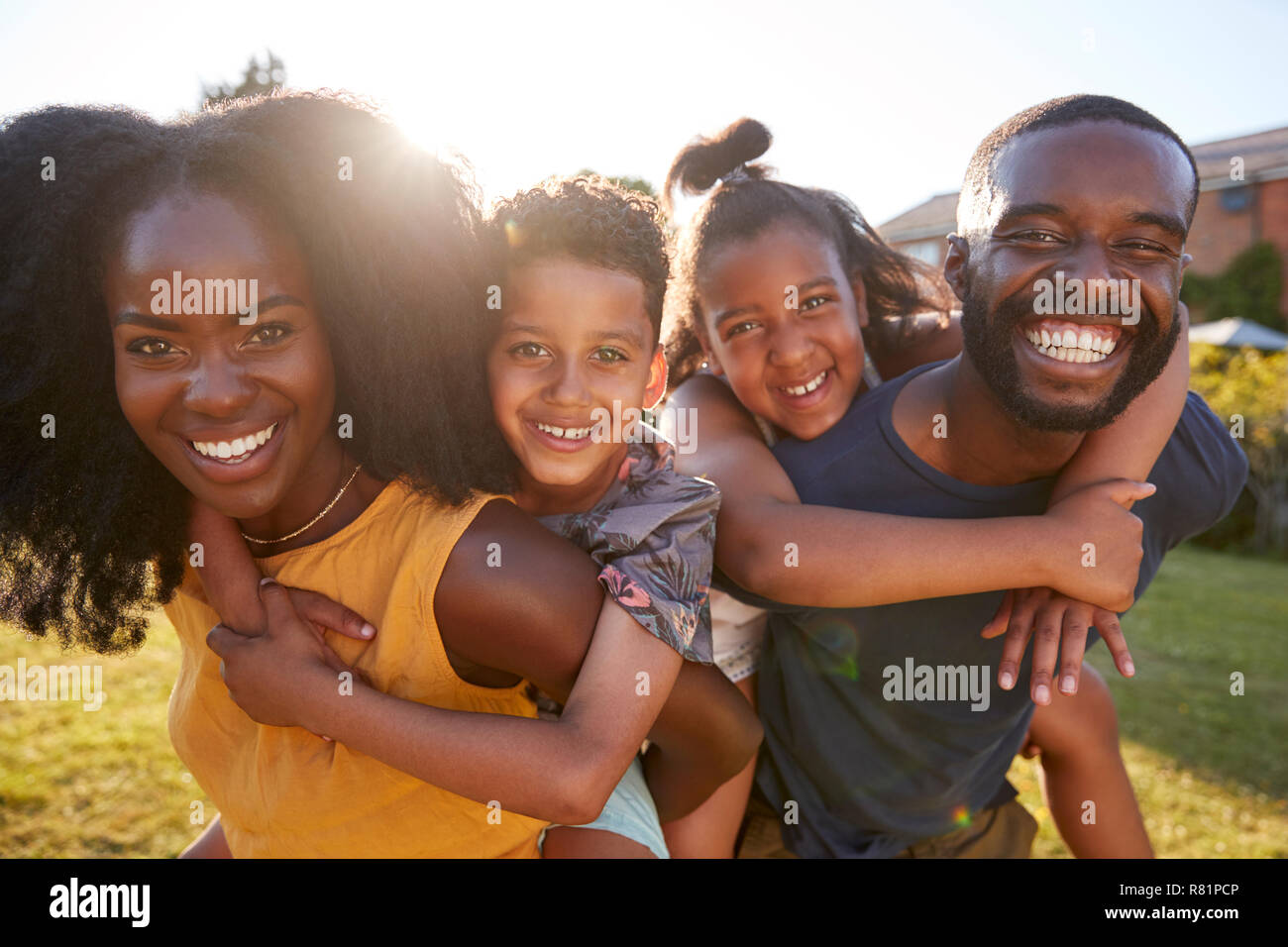 Schwarze Eltern huckepack Ihre jungen Kinder, in der Nähe Stockfoto