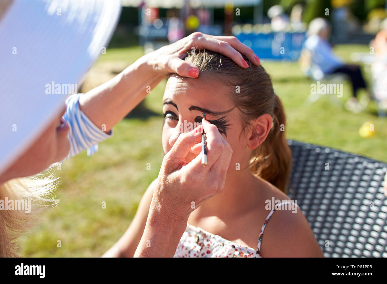 Mädchen am Kinderschminken Abschaltdruck am Sommer Garten Fete Stockfoto