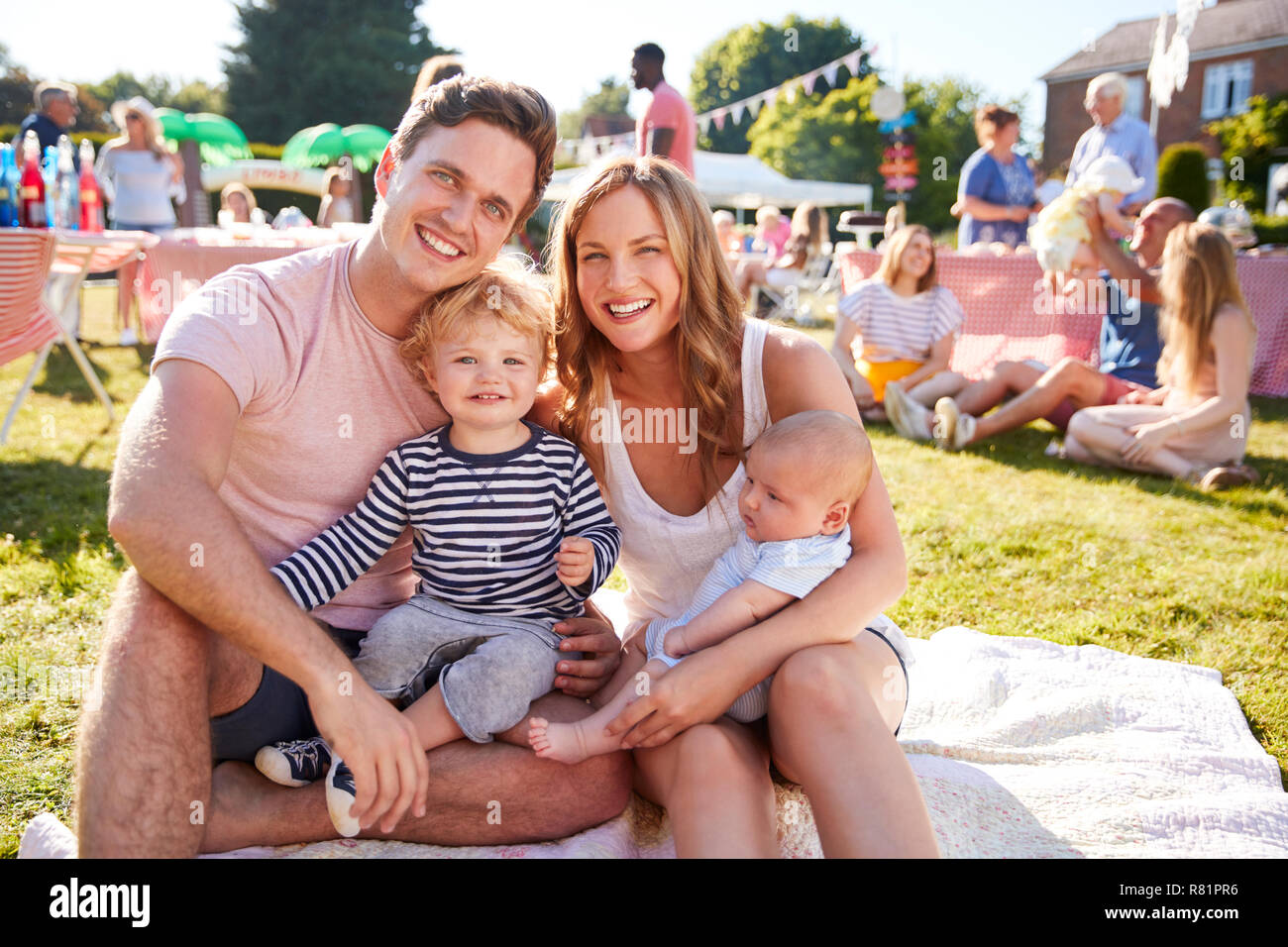 Porträt der Familie mit Kindern sitzen auf Teppich bei Sommer Garten Fete Stockfoto
