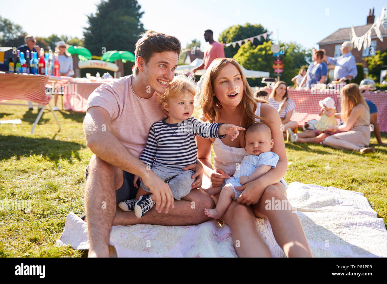 Familie mit Kindern sitzen auf Teppich bei Sommer Garten Fete Stockfoto