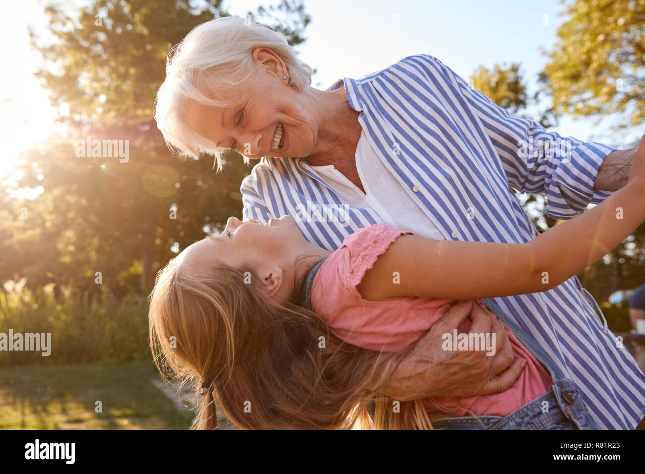 Großmutter, die Spiel und Tanz mit Enkeltochter im Sommer Park Stockfoto