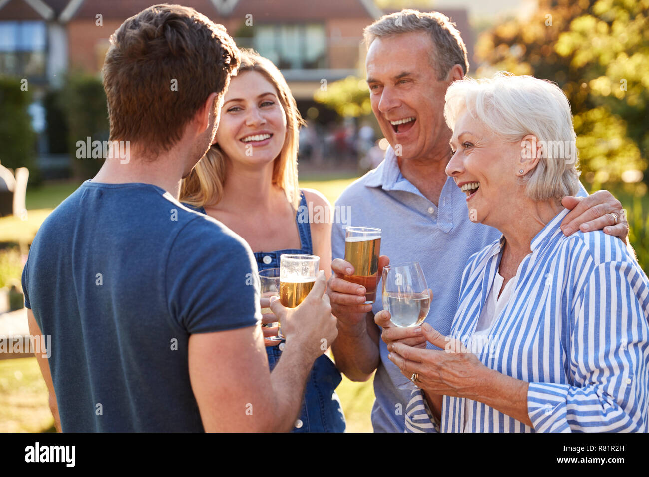 Eltern mit erwachsenen Nachkommen genießen im Sommer trinken im Pub Stockfoto