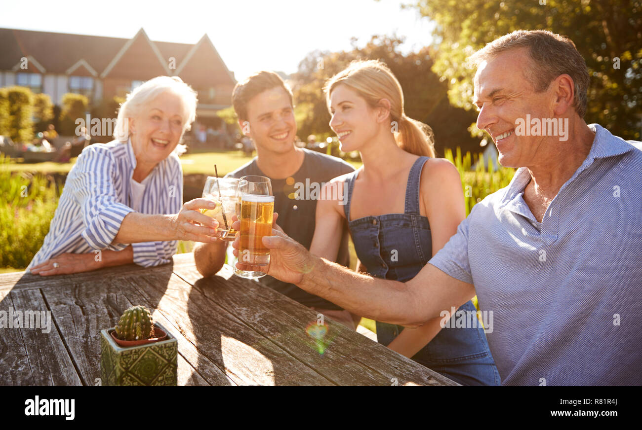 Eltern mit erwachsenen Nachkommen genießen im Sommer trinken im Pub Stockfoto