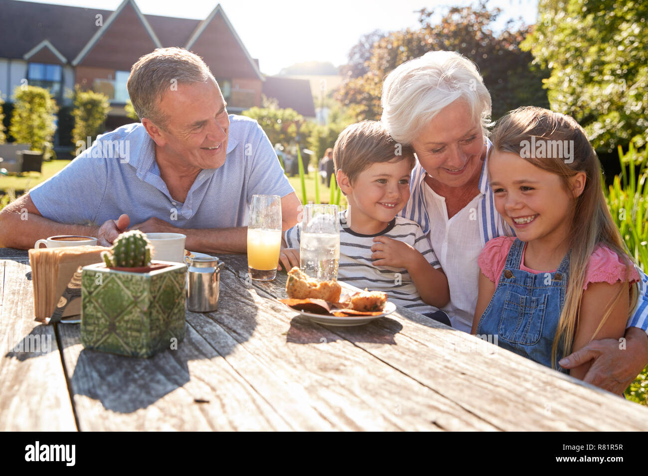 Großeltern mit Enkeln genießen Sie im Sommer einen Snack im Cafe Stockfoto